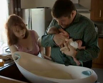Adele and Laurence giving the baby a bath